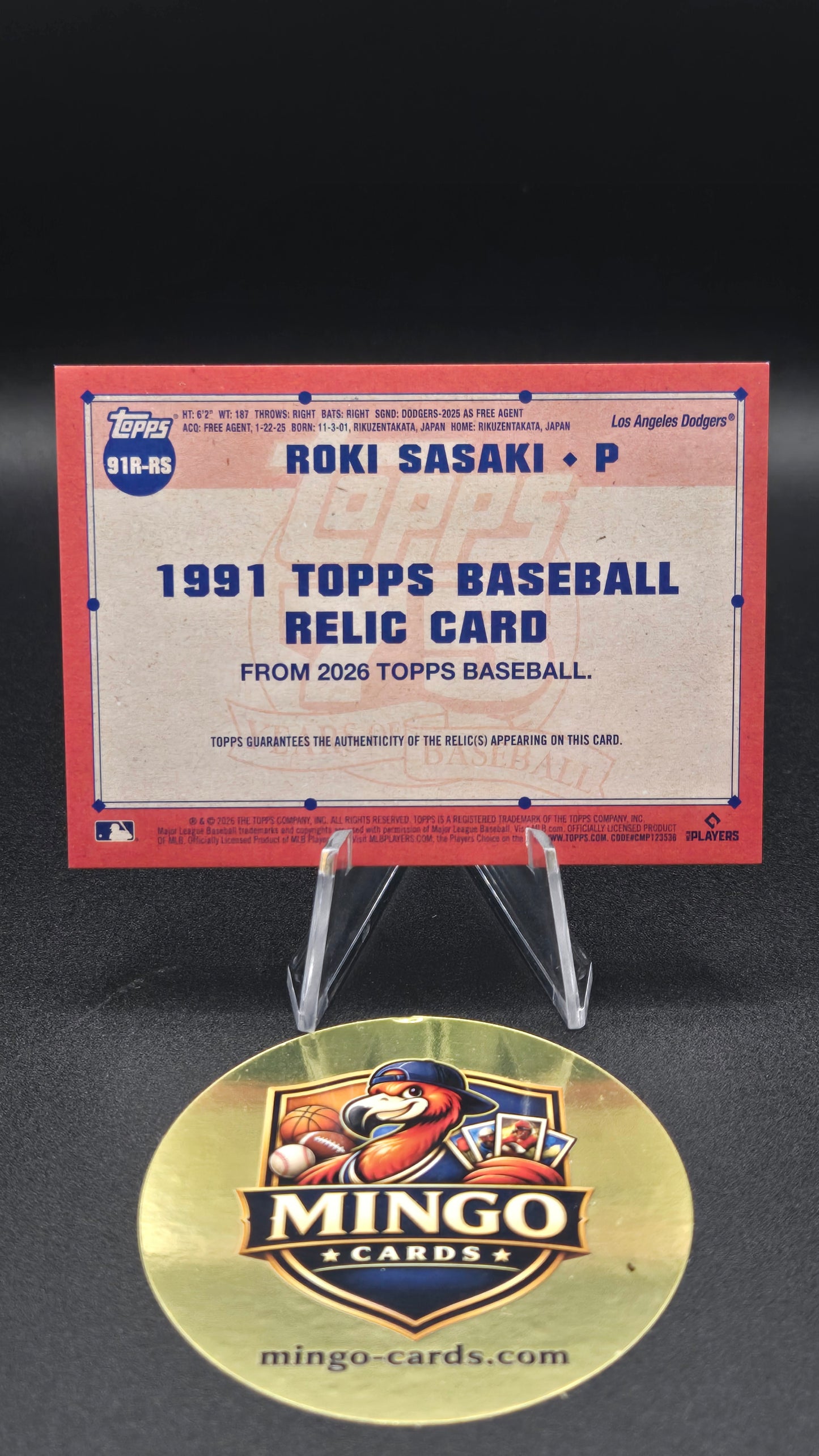 A 1991 Topps baseball relic card featuring Ron Sasaki, displayed on a clear stand next to a round gold Mingo Cards collectible medallion on a black background.