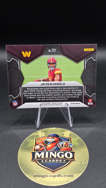 A collectible football trading card of Jayden Daniels displayed on a clear stand next to a round gold Mingo Cards sticker on a black background.