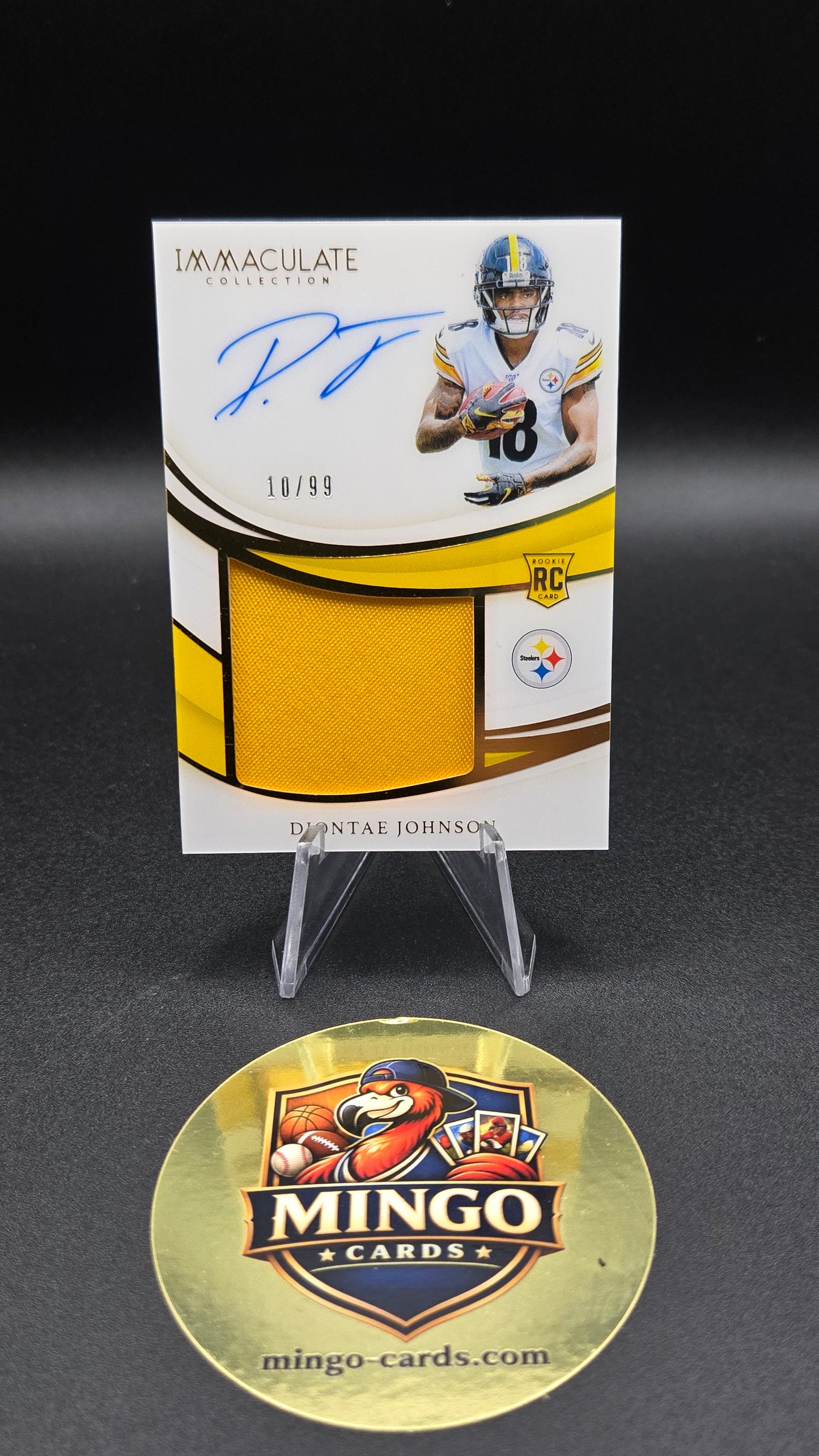 An autographed Immaculate Collection 2013 football card of Diontae Johnson, displayed on a clear stand above a gold Mingo Cards collector's medallion on a black background.