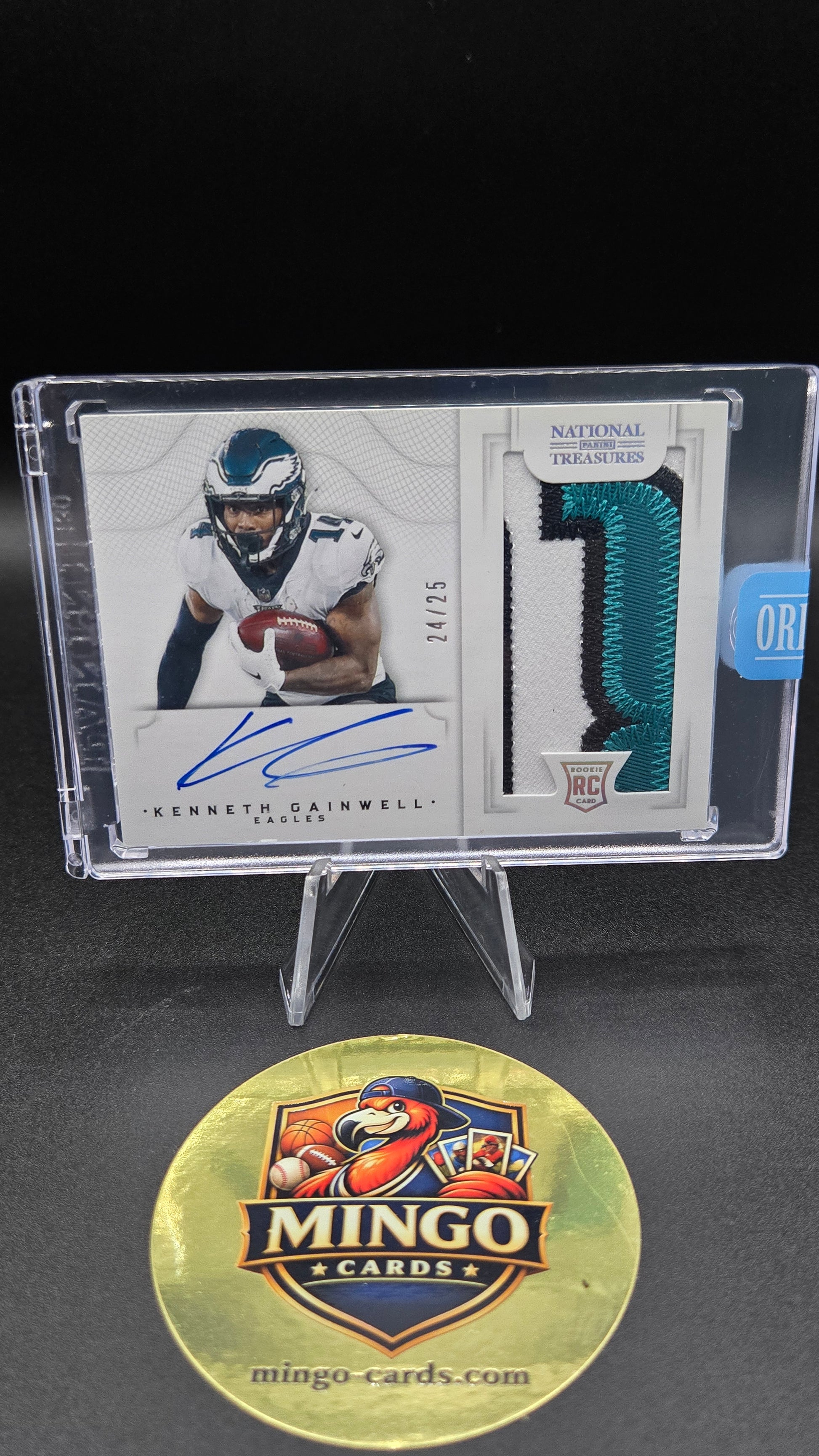 A signed Kenneth Gainwell National Football League trading card in a clear plastic display case, shown next to a gold Mingo Cards promotional medallion on a black background.