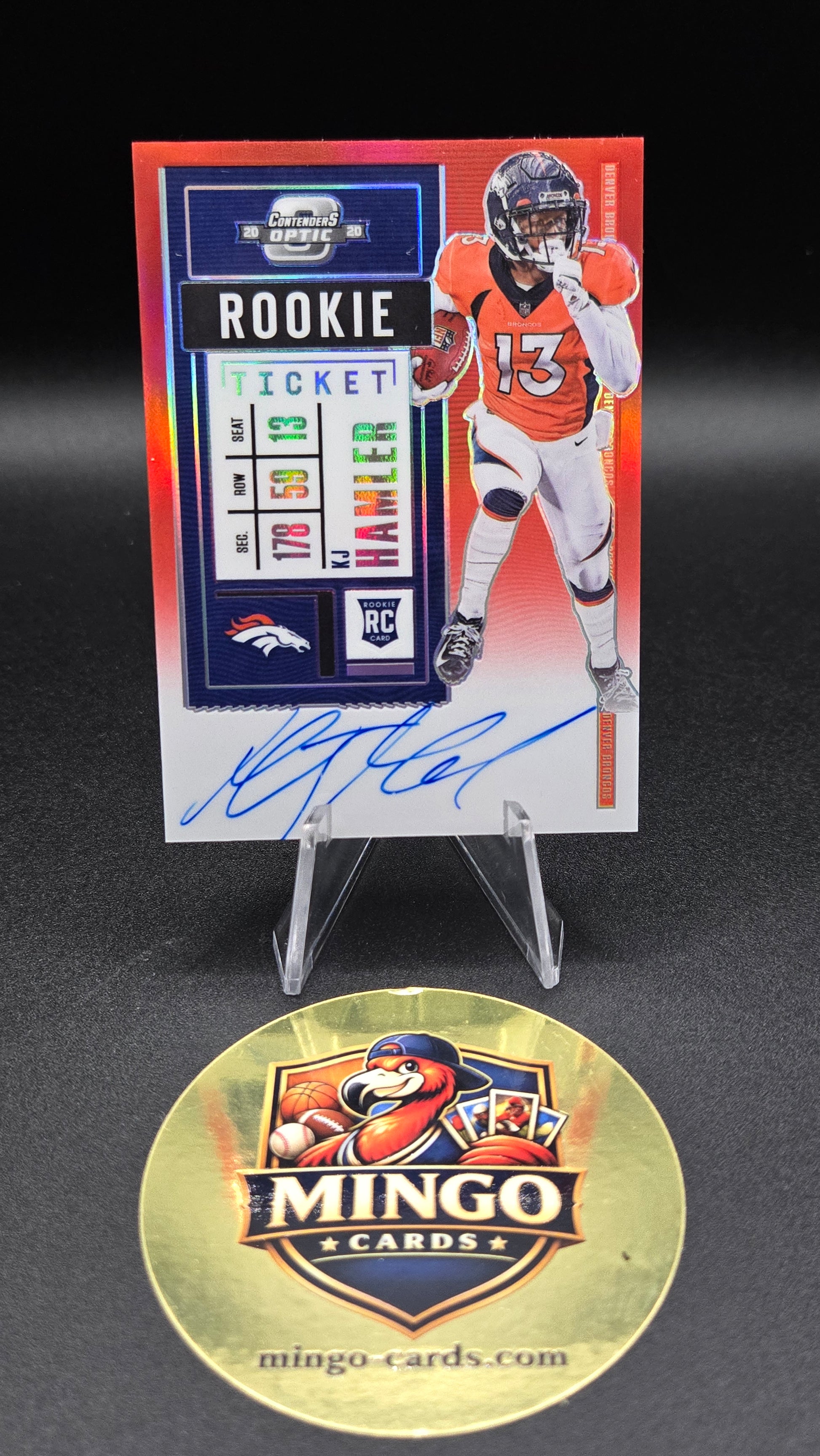 An autographed Denver Broncos football trading card displayed next to a round gold Mingo Cards promotional coin on a black background.