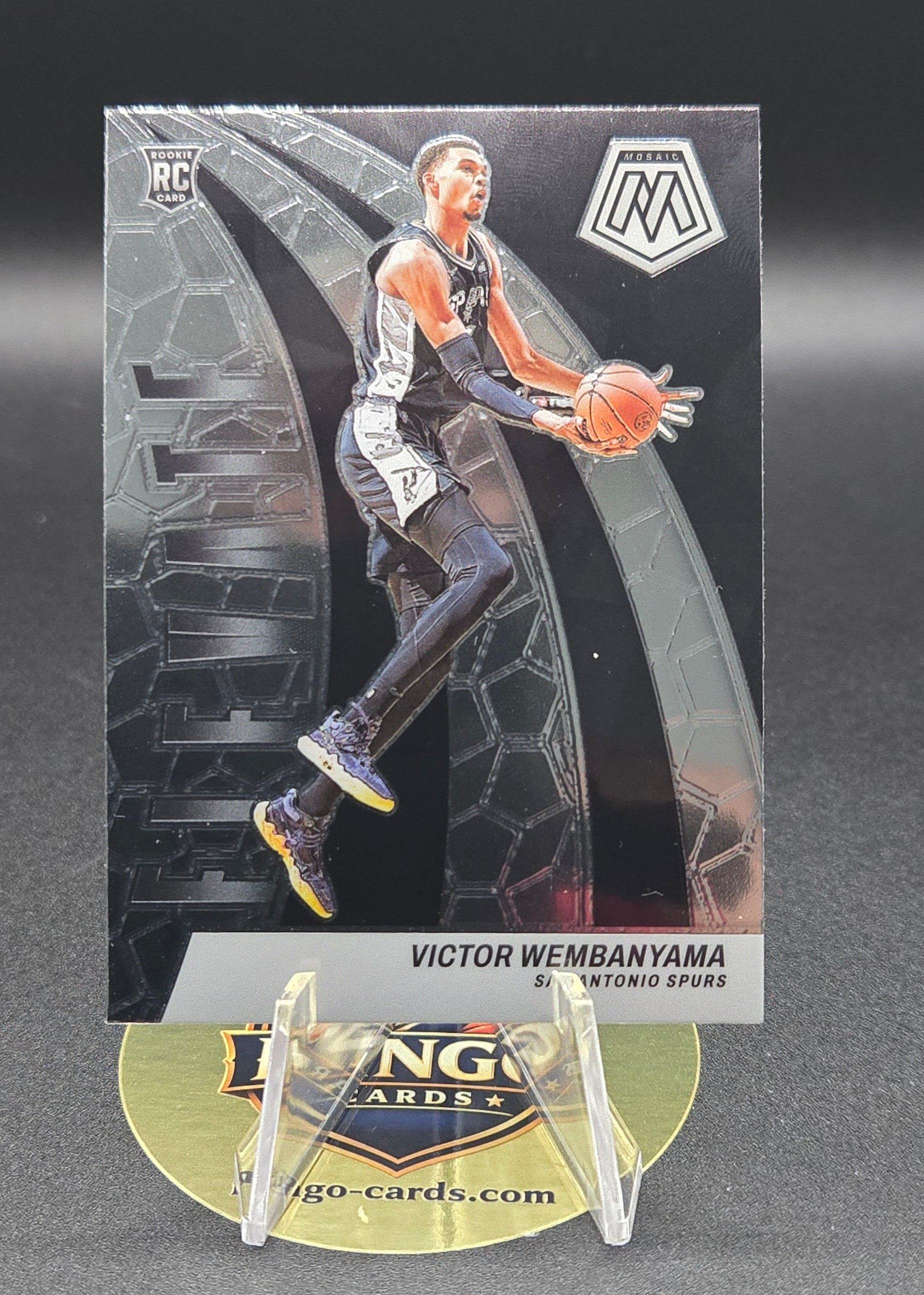 Trading card of a basketball player with a gold border on a gray background