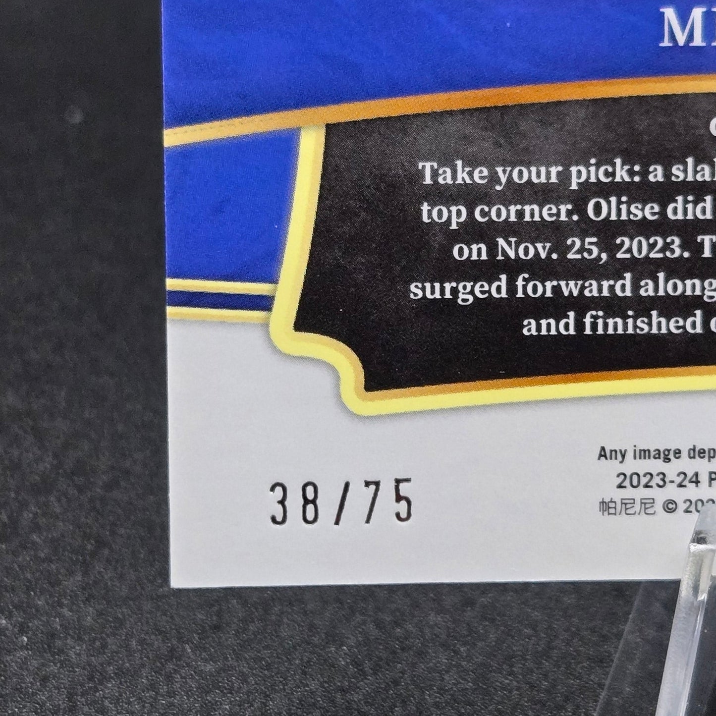 Trading card with blue and gold design on a dark background showing 38/75 serialized card