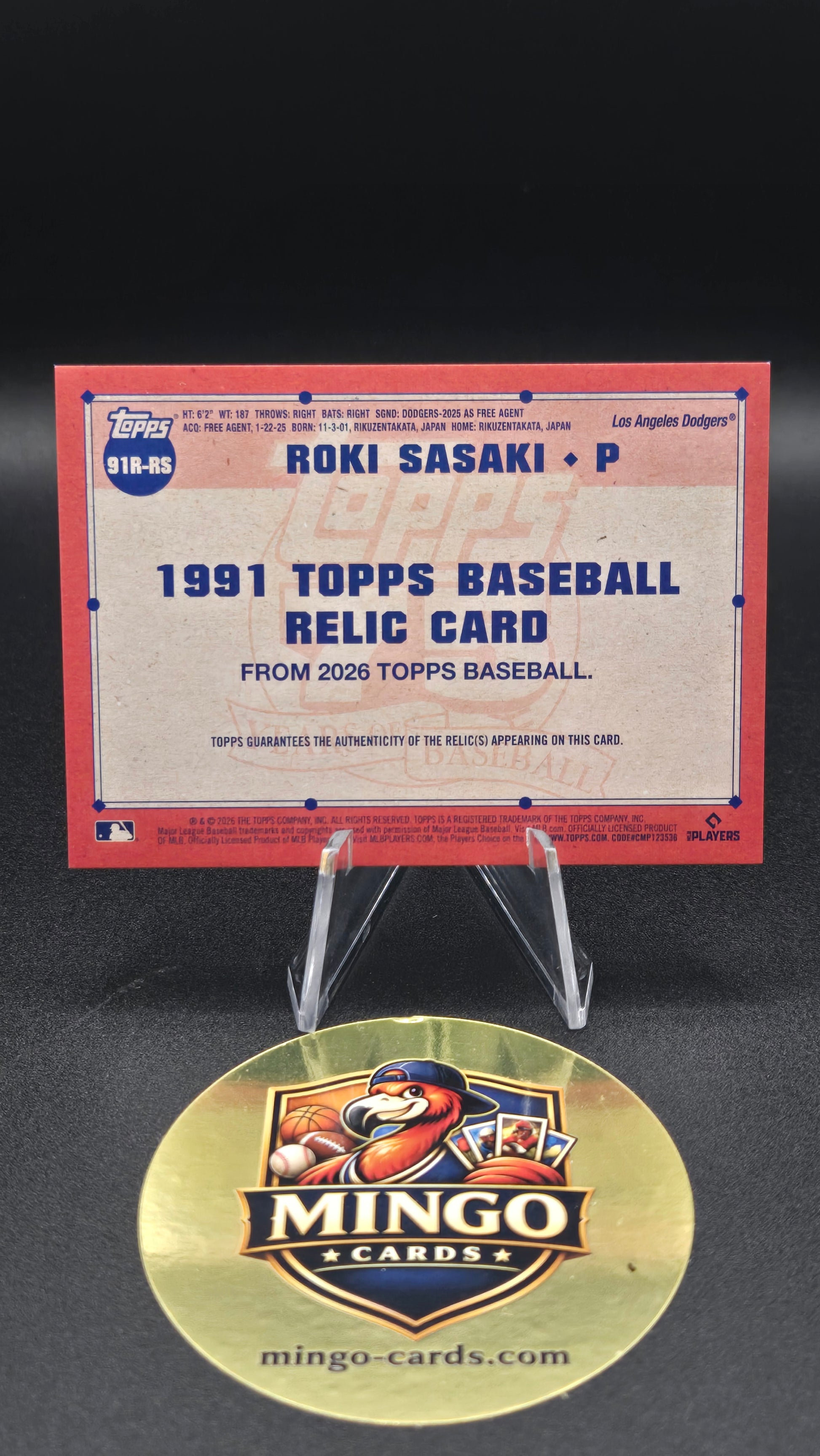 A 1991 Topps baseball relic card featuring Ron Sasaki, displayed on a clear stand next to a round gold Mingo Cards collectible medallion on a black background.