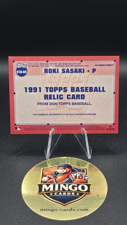A 1991 Topps baseball relic card featuring Ron Sasaki, displayed on a clear stand next to a round gold Mingo Cards collectible medallion on a black background.